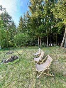 a group of chairs sitting in the grass at Pomiędzy Jeziorami in Kleszczówek
