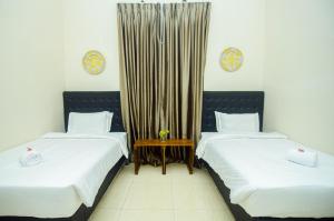 dos camas sentadas una al lado de la otra en una habitación en GILI VIEW By Kalma, en Teluknarat