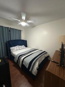 a bedroom with a bed and a ceiling fan at Aiden Mansion in London