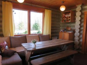 a living room with a couch and a wooden table at Guest House Lēveri in Valgalciems