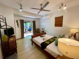 a bedroom with a bed and a tv and a couch at Karinya in Clifton Beach
