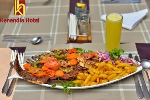 a plate of food on a table with a plate of food at Kenendia Hotel in Kampala