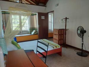 a bedroom with a bed and a window with a cross at Majestic Apartments in Nawala