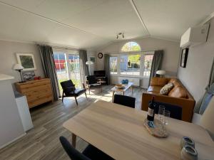 een woonkamer met een tafel en een bank bij De Roos chalet 174 in Sint Annaland