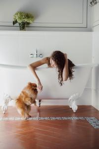 Una donna che si appoggia a una vasca da bagno con un cane di Torre a Cona Wine Estate a Firenze