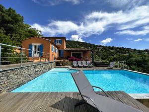- une piscine avec une chaise et une maison dans l'établissement Villa CORAIL privée et climatisée pour 10 personnes avec piscine et superbe vue mer et collines à La Londe-les-Maures, à La Londe-les-Maures