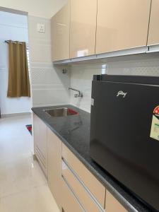 班加羅爾的住宿－Room2Go，厨房配有水槽和黑色台面