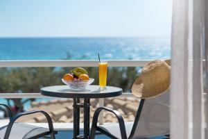 a table with a bowl of fruit and a glass of juice at BOGGI in Goúdhouros