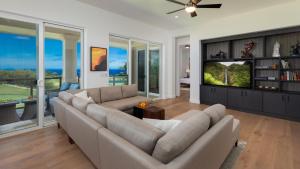 a living room with a couch and a flat screen tv at SUN RAY RETREAT Ocean Sunsets Views Optional Mauna Kea Hotel Privileges in Waimea