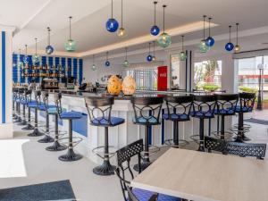 a bar with blue stools in a restaurant at Grupotel Maritimo in Port d'Alcudia