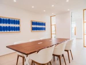 a dining room with a wooden table and white chairs at Grupotel Maritimo in Port d'Alcudia