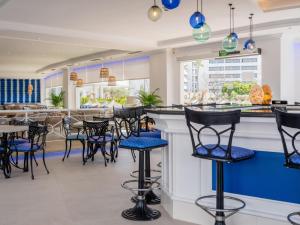 a restaurant with black and blue bar stools at Grupotel Maritimo in Port d'Alcudia