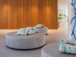 two ottomans with pillows on them in a room at Grupotel Maritimo in Port d'Alcudia