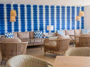 a living room with wicker chairs and a couch at Grupotel Maritimo in Port d'Alcudia