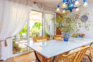 a dining room with a white table and chairs at Casa S'Olivaret -Selva- in El Port de la Selva