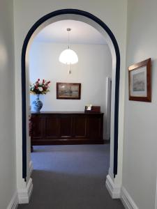 an archway leading into a room with a vase of flowers at Arthurton Central in Hobart