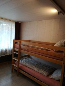 a room with three bunk beds with a window at Ritterstübli in Hasliberg