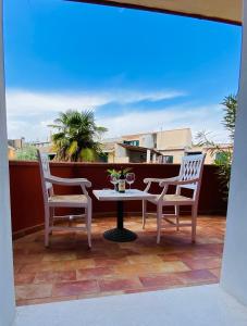 d'une terrasse avec 2 chaises et une table sur un balcon. dans l'établissement Locanda degli Artisti, à Tortolì