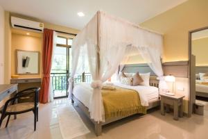 1 dormitorio con cama con dosel y balcón en Radateeree Boutique Resort en Chiang Mai