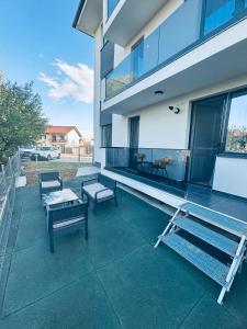 a balcony of a building with benches and tables at Golden Apartament in Şelimbăr