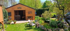 a garden with a shed with a table and chairs at Domeczek Sami in Łunowo