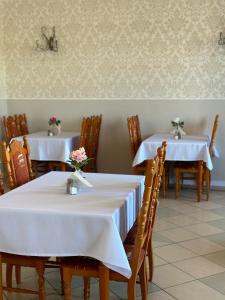 two tables in a restaurant with white table cloth at Pensjonat Diament in Borne Sulinowo
