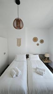 Duas camas num quarto com paredes brancas em Enalia Studio em Korissia