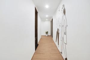 a hallway with a white wall with drawings on it at Super Townhouse 158 Near Netaji Subhash Marg Near Appu Ghar in Gurgaon