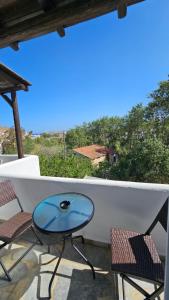 a table and chairs on a balcony with a view at Enalia Studio in Korissia +21 photos