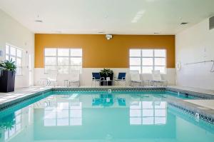 a swimming pool with chairs and a table in a building at Best Western Timpanogos Inn in Lehi