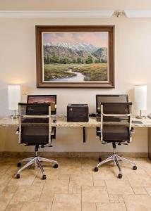 Habitación con 2 escritorios con sillas y una pintura en la pared. en Best Western Timpanogos Inn en Lehi