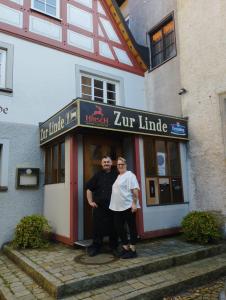 due persone in piedi sulla porta di un edificio di Zur Linde a Mühlheim an der Donau