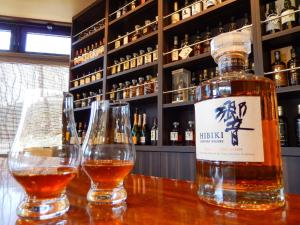 dwa kieliszki wina siedzące na barze z butelką whisky w obiekcie Kumonoue Fuji Hotel - Vacation STAY 13699v w mieście Oishi