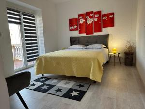 una camera da letto con un letto con dipinti rossi sul muro di Apartment Peloža 1 a Poreč (Parenzo)