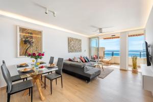 ein Wohnzimmer mit einem Sofa und einem Tisch in der Unterkunft BEACHFRONT -- NEW LUXURY Apartment -- 1ª Linea Playa -- Fuengirola CITY CENTER -- Private PARKING -- Panoramic Sea Views -- in Fuengirola