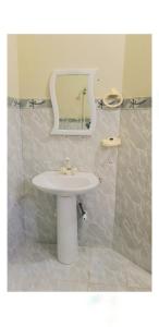 y baño con lavabo blanco y espejo. en Regal Guest House, en Bahawalpur