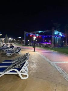 a row of lounge chairs on a beach at night at 5 stars Studio Aqua View North coast in Borg El Arab