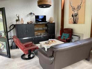 ein Wohnzimmer mit einem Sofa und einem Tisch in der Unterkunft Le petit gîte in Vresse-sur-Semois