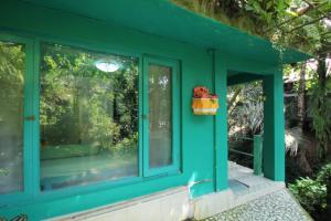 een groen huis met een raam bij Belvilla 93915 Bamboo Villa Near Central Ubud in Ubud