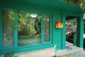 ein grünes Haus mit zwei Seitenfenstern in der Unterkunft Belvilla 93915 Bamboo Villa Near Central Ubud in Ubud