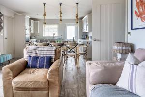 a living room with two couches and a dining room at Gwendy in Abersoch