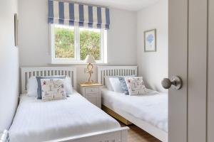 two twin beds in a bedroom with a window at Gwendy in Abersoch