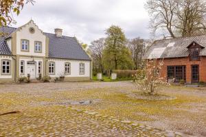 a large white house and a brick building at Fredensgaard nær Billund in Jordrup