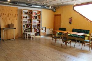 Habitación con mesa, sillas y estante para libros. en La Choza de Trasmulas, en Trasmulas