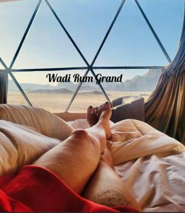 a person laying on a bed in a hammock at Wadi Rum Grand in Wadi Rum