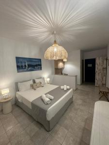 a bedroom with a large bed and a chandelier at Dedes Apartments in Skala
