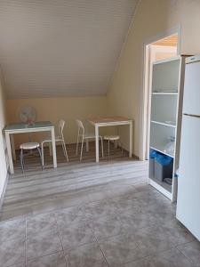 eine Küche mit einem Tisch, einem Tisch und einem Kühlschrank in der Unterkunft MiniBali Apartmanok in Siófok