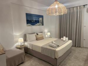a bedroom with a large bed and a chandelier at Dedes Apartments in Skala