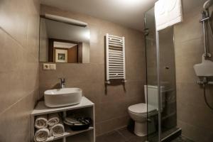 un bagno con lavandino, water e specchio di Tea for Two Hotel a Tbilisi City