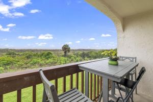 a table and chairs on a balcony with a view at Life's a Beach-Oceanfront condo in Saint Augustine Beach